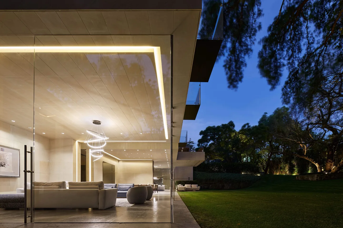 Casa CO: estancia abierta al jardín al anochecer