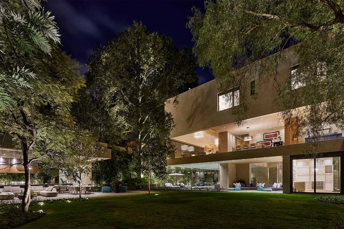 Casa LU: fachada al jardín al anochecer, entre árboles