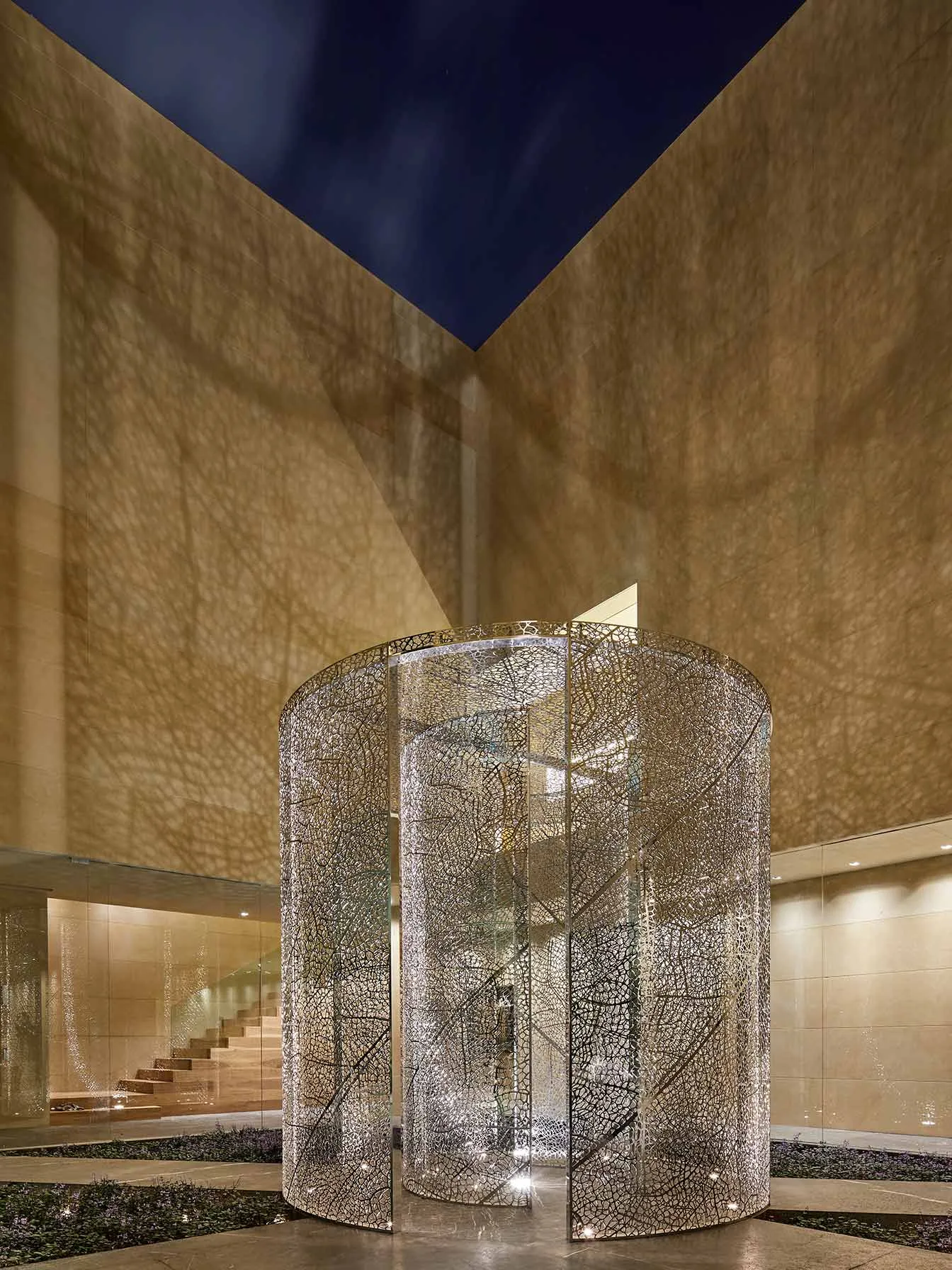 Casa LU: escultura cilíndrica perforada de Jan Hendrix iluminada de noche
