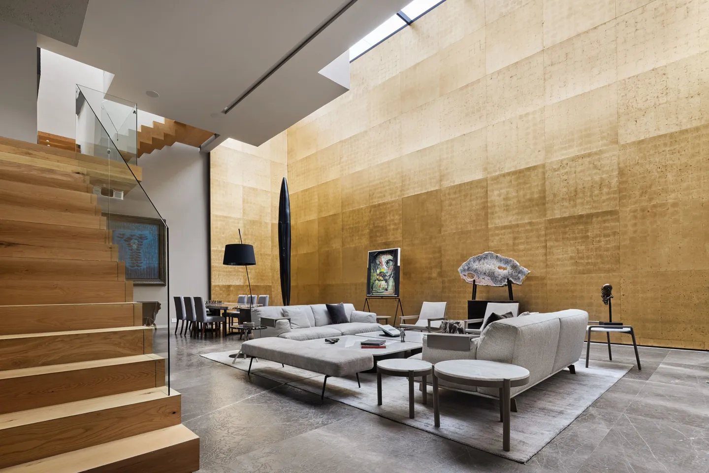 Casa DR: sala de doble altura con muro de madera y escalera flotante