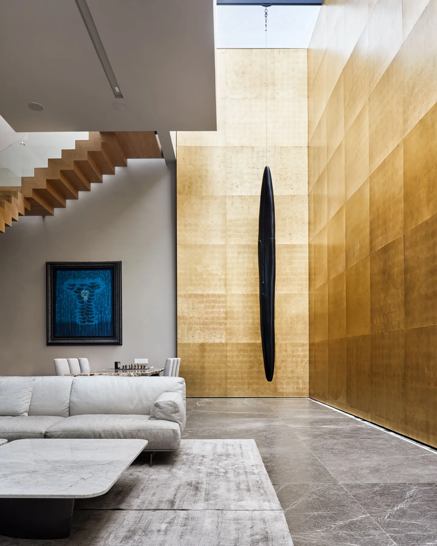 Casa DR: escalera de madera junto al muro de doble altura