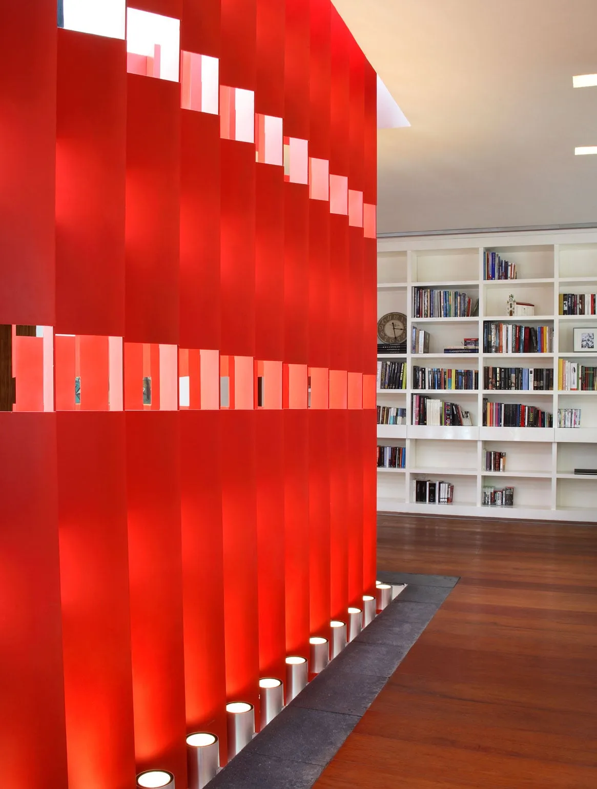 Casa F1: lamas rojas que separan la estancia de la biblioteca