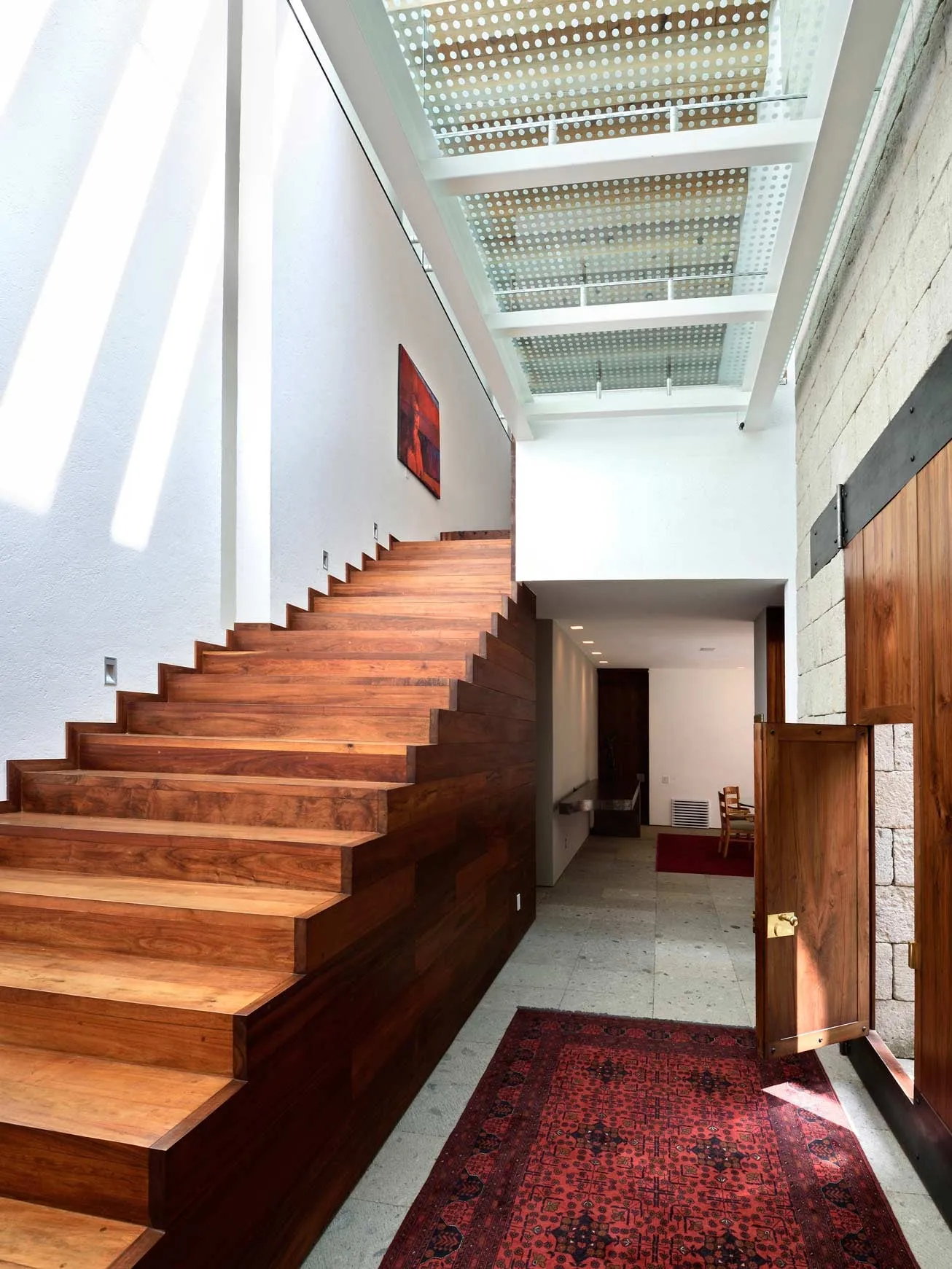 Casa FR: escalera de madera bajo un tragaluz a lo largo de un pasillo