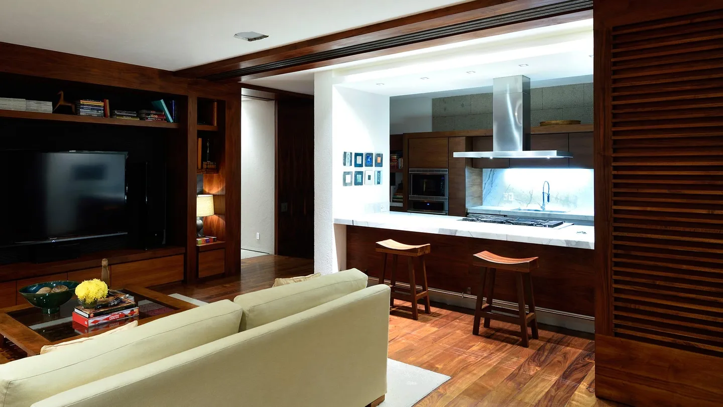 Casa FR: estancia abierta a la cocina con muebles de madera