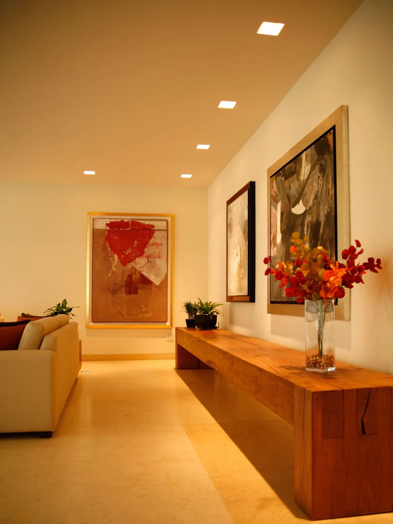 Casa FU: galería con mueble de madera y pinturas