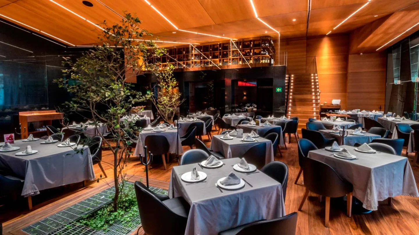 Centro Asturiano Polanco: restaurante con árboles interiores y plafón de madera