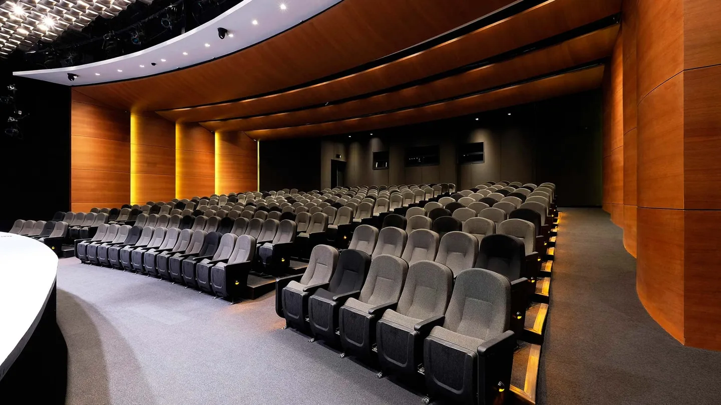 Centro Asturiano Polanco: auditorio con butacas y muros curvos de madera