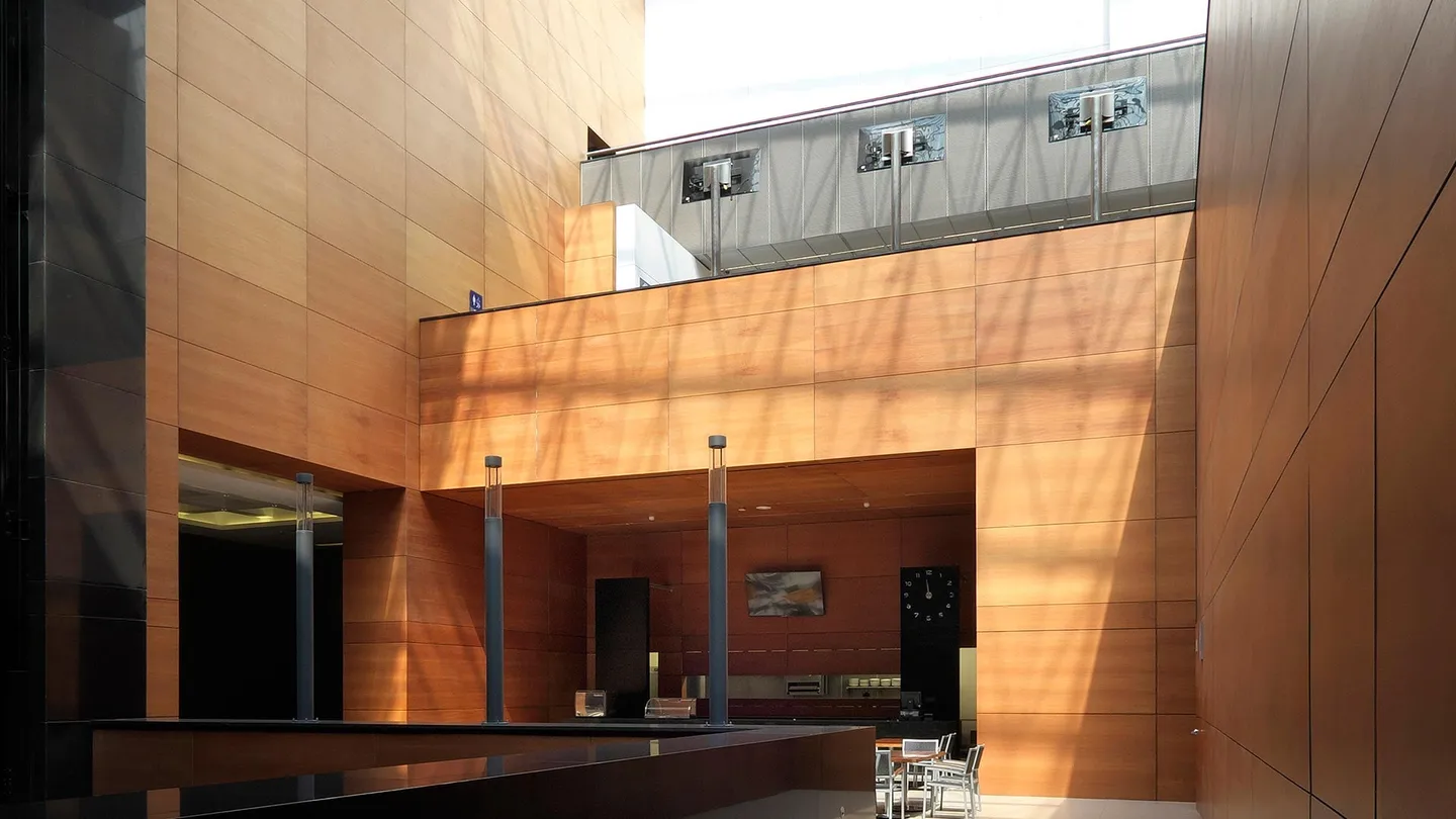 Centro Asturiano Polanco: atrio de muros de madera bajo una cubierta de luz