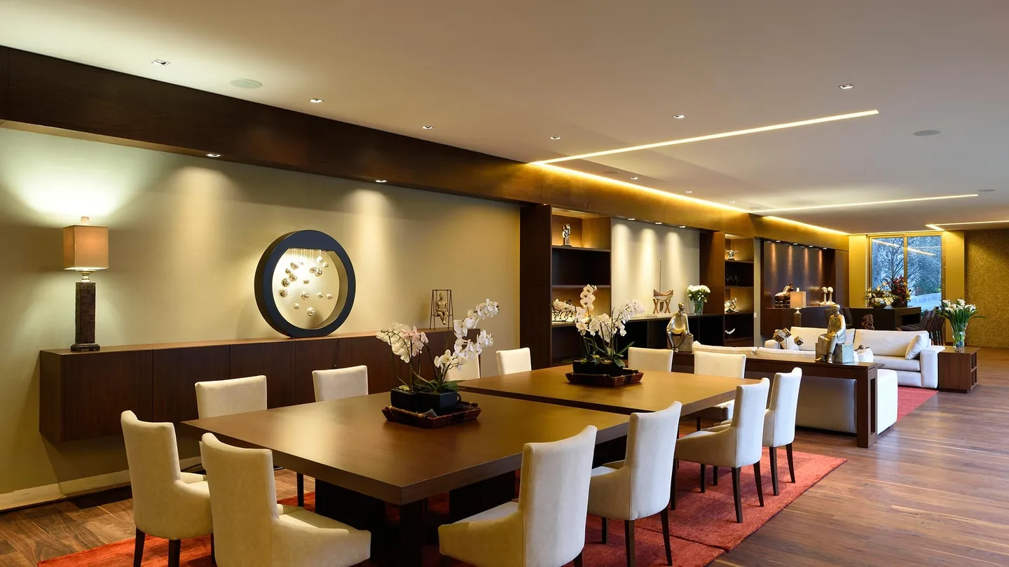 Casa CR: comedor y estancia con iluminación cálida