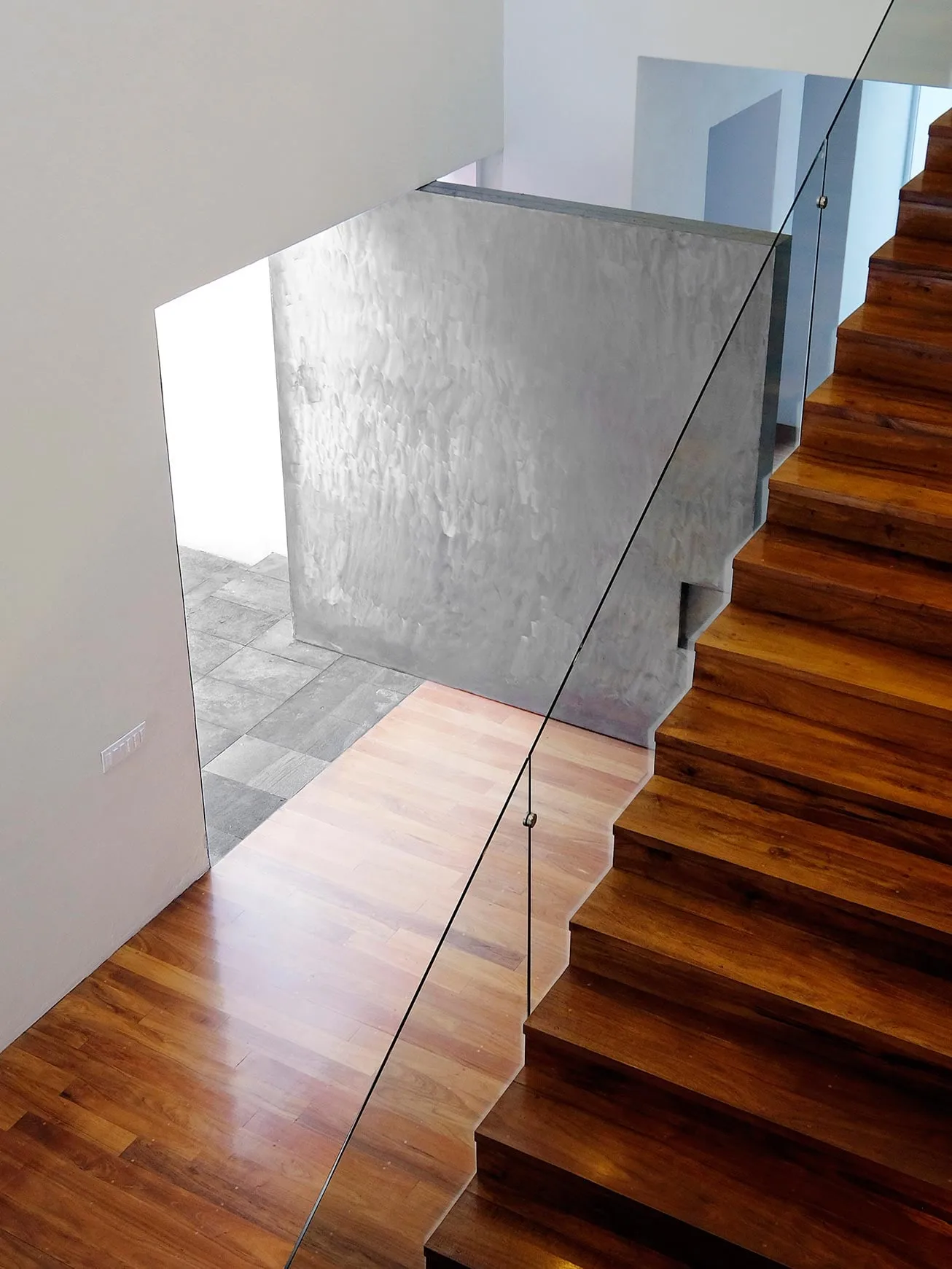 Casa TE: escalera de madera con barandal de vidrio