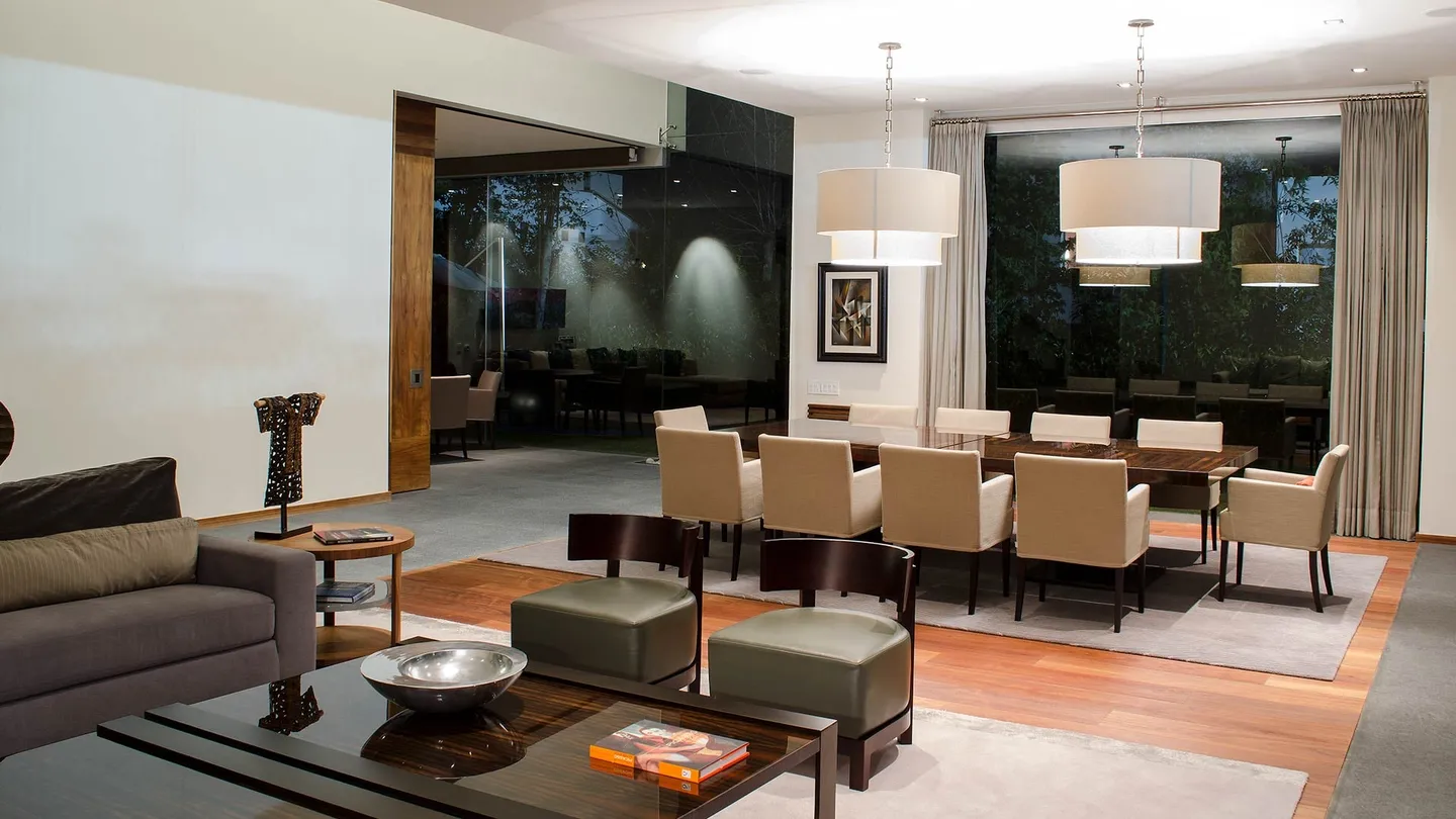 Casa CU: estancia y comedor con lámparas de tela y piso de madera