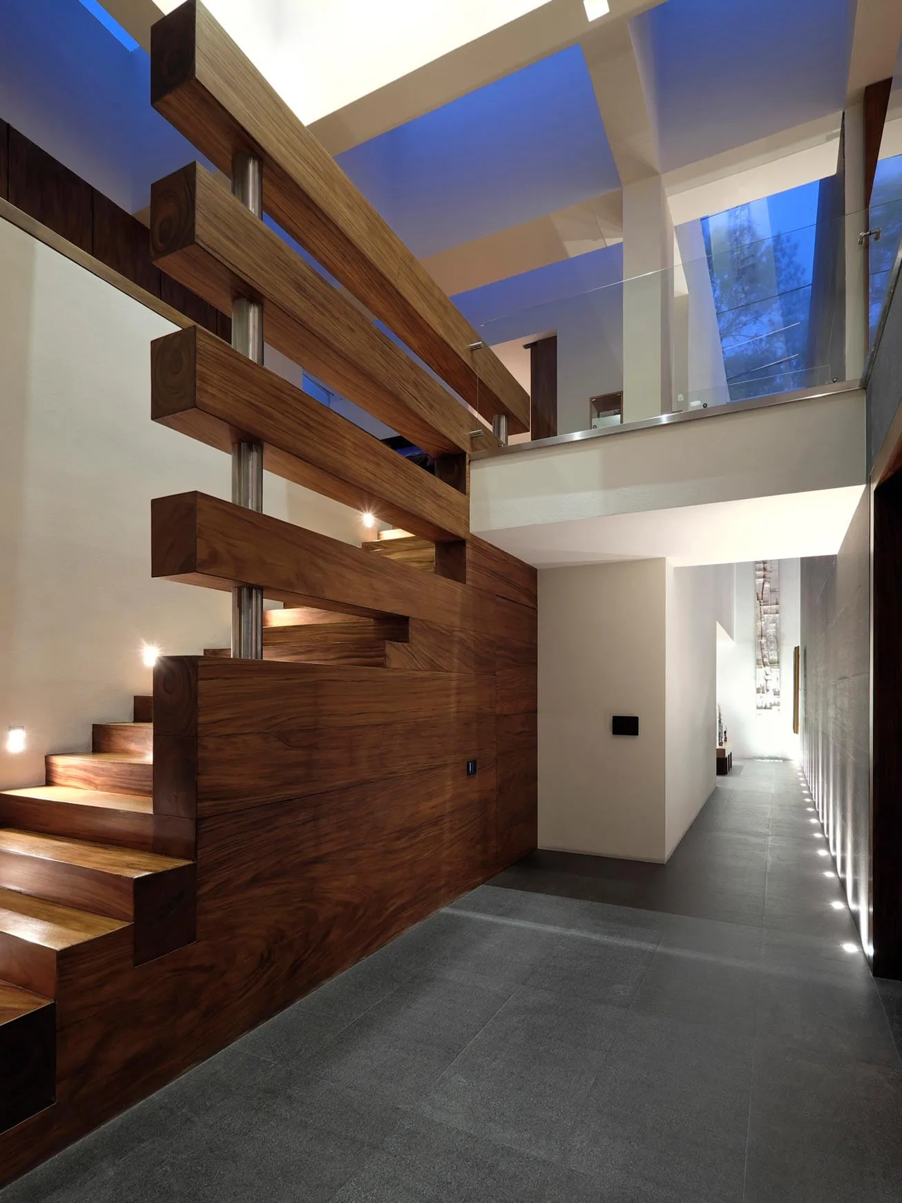 Casa FU3: escalera de peldaños de madera volados bajo un tragaluz