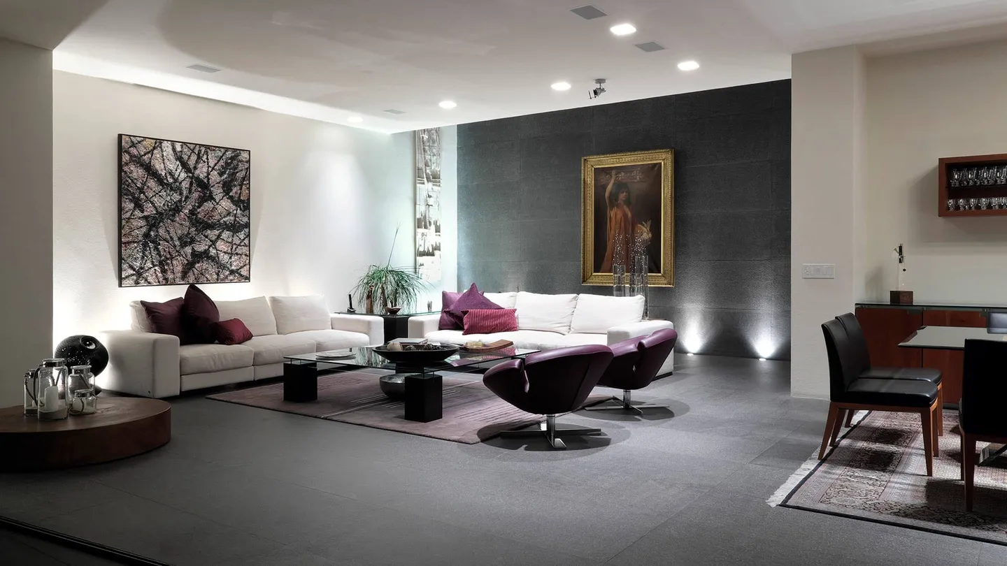 Casa FU3: estancia de muros claros y piso gris con sillones morados