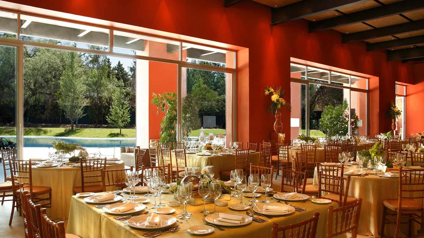 Hacienda San Miguel: salón de eventos con mesas montadas y ventanales a la alberca