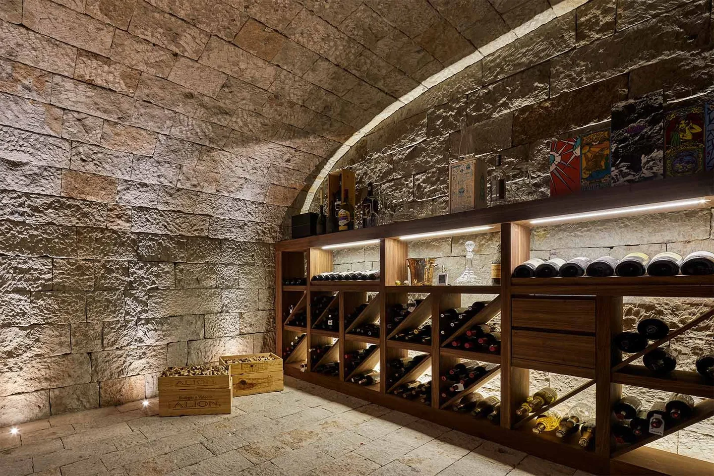 Casa IG: cava bajo una bóveda de piedra con estantería de madera