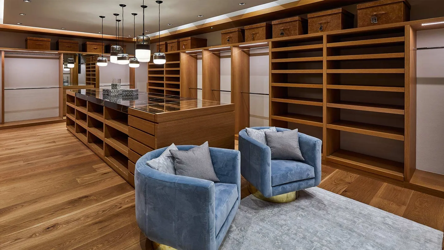Casa LA: vestidor de madera con sillones azules