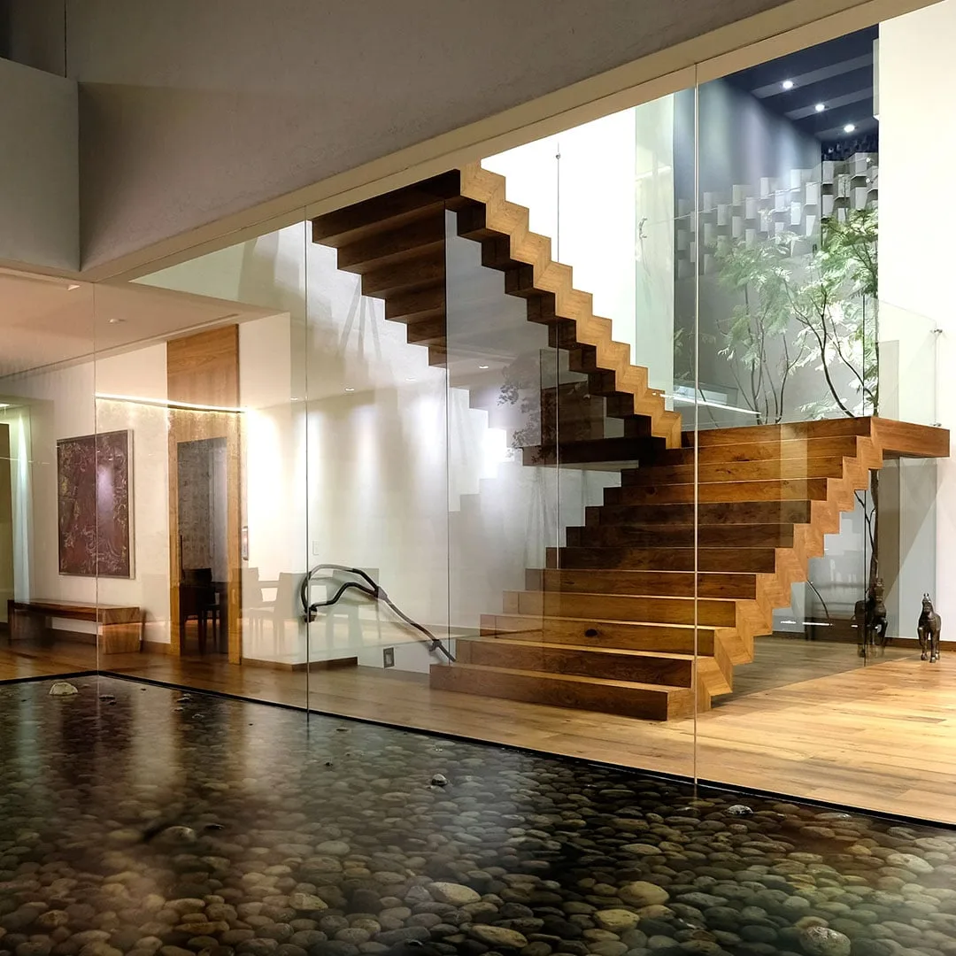Casa LV: escalera de madera sobre un espejo de agua interior