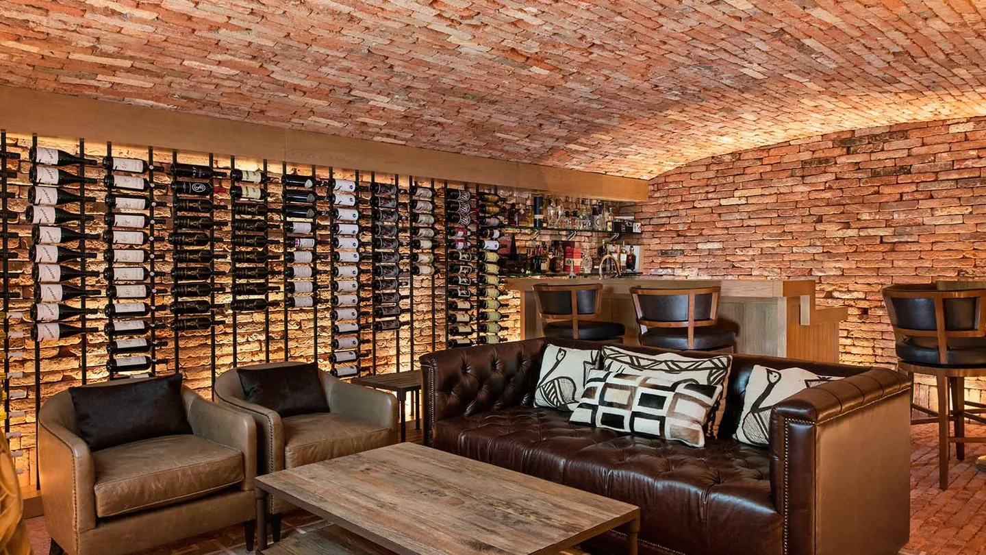 Casa OC: cava con bóveda de ladrillo y estantería de vinos