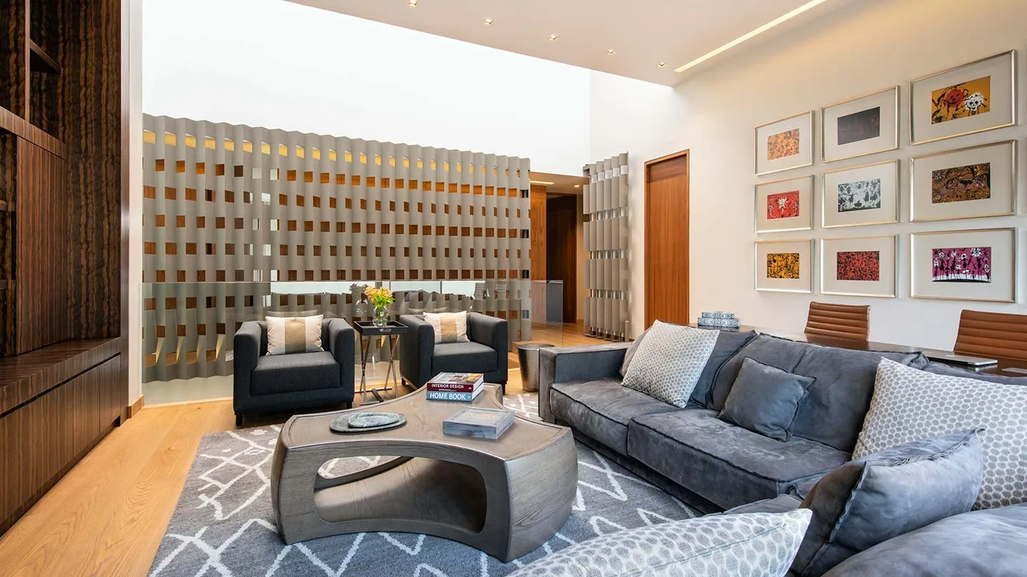Casa OC: estancia con celosía de piedra y colección de grabados