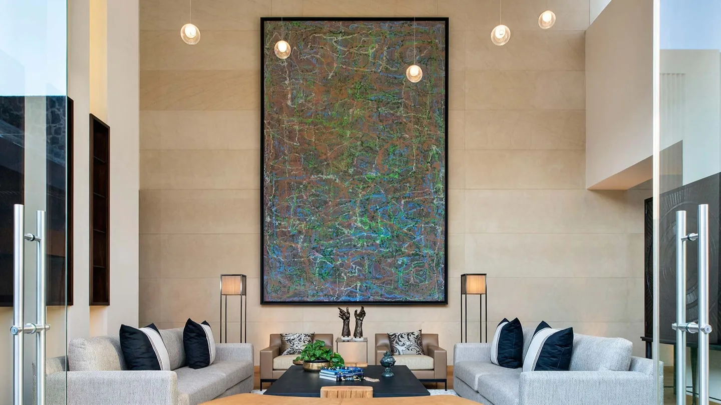 Casa OC: sala a doble altura con un gran cuadro abstracto