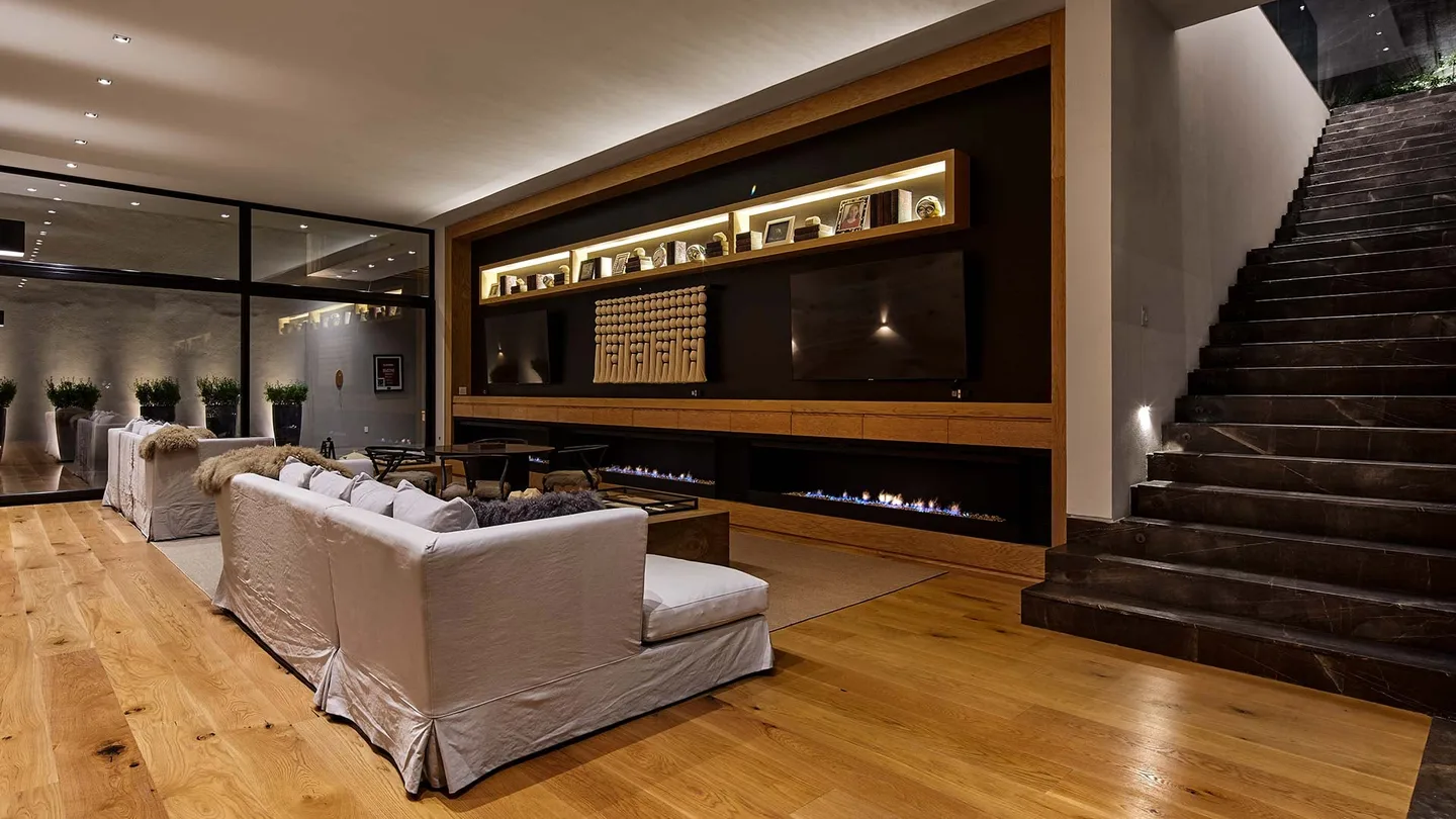 Casa VB: estancia con chimenea lineal y escalera de piedra