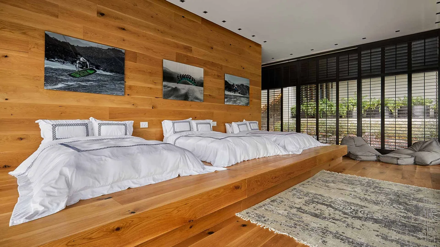 Casa VB: recámara revestida de madera con vista al bosque