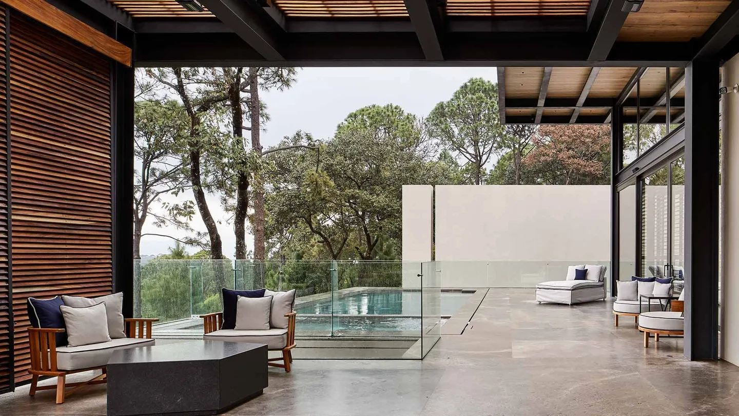 Casa VB: terraza con alberca de borde infinito entre los árboles