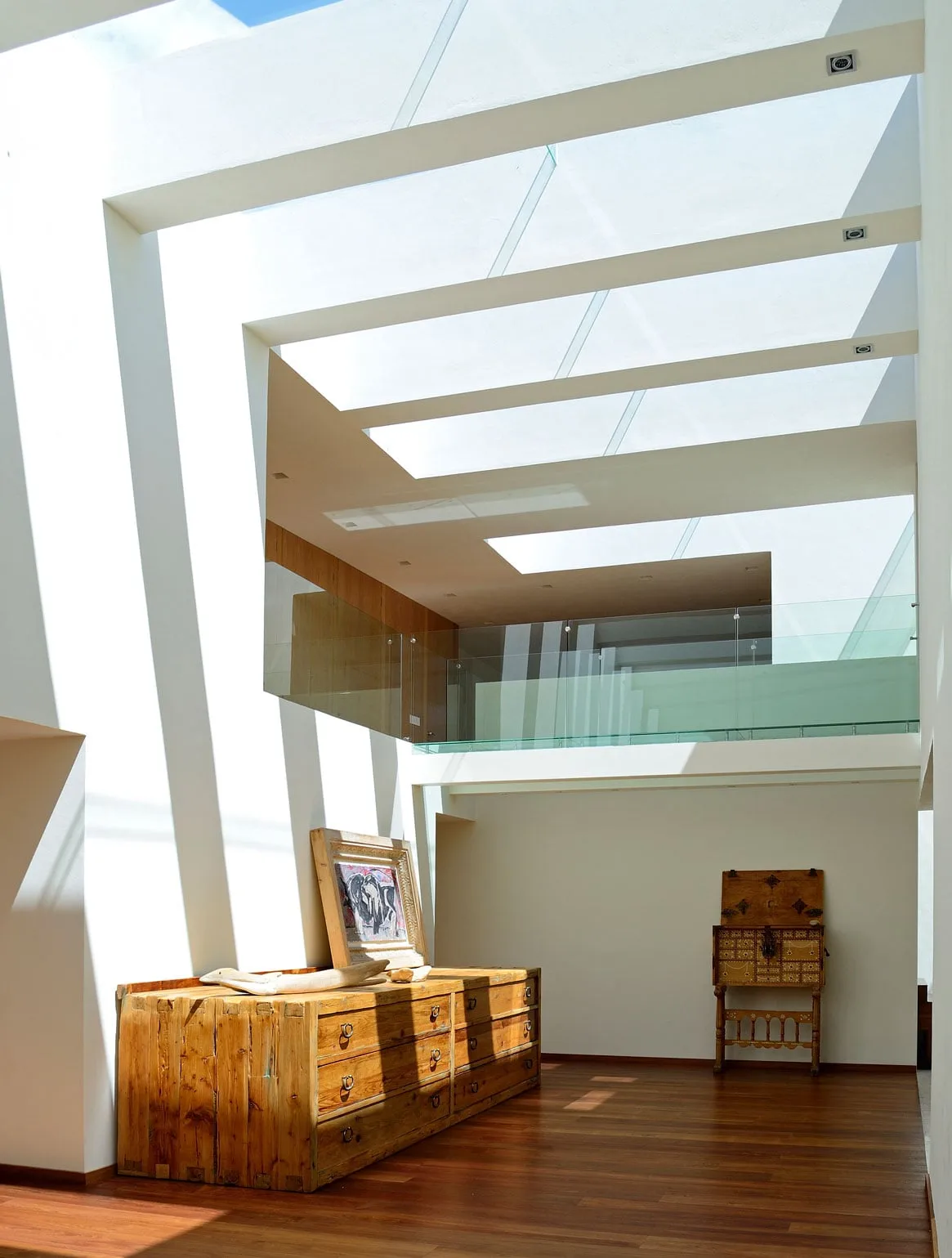 Casa VE: doble altura con tragaluces y mueble de madera rústica